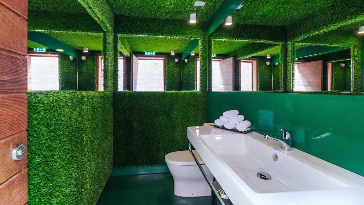 or-take-a-bath-in-what-feels-like-the-middle-of-a-stadium-surrounded-by-green-textured-walls-that-mimic-the-grass-on-a-football-field